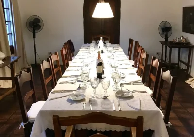 Dining table set for a meal at El Palomar Hunting Lodge, featuring elegant tableware, wine bottles, and a spacious atmosphere, reflecting the lodge's welcoming hospitality and traditional Argentine ranch character.