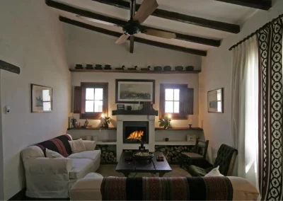 Cozy living room at El Palomar Hunting Lodge featuring a fireplace, traditional decor, and comfortable seating, highlighting the lodge's welcoming atmosphere for hunters in Argentina.