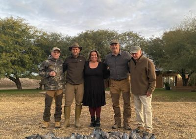 Group of hunters posing with harvested pigeons at Estancia La Emilia, showcasing a successful shooting experience in the scenic Catamarca Province.