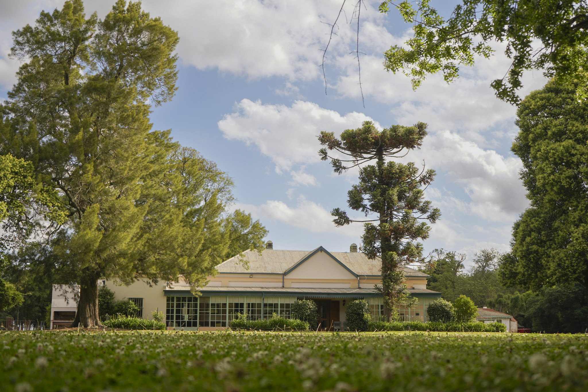 Refined manor at La Paz overlooking a nature reserve, surrounded by lush greenery, emphasizing elegant duck hunting in the Lowland Pampas.