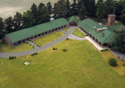 Aerial view of Estancia Las Palomas lodge in Argentina, featuring green roofs, manicured lawns, and surrounding trees, emphasizing its traditional accommodation for dove hunting adventures.