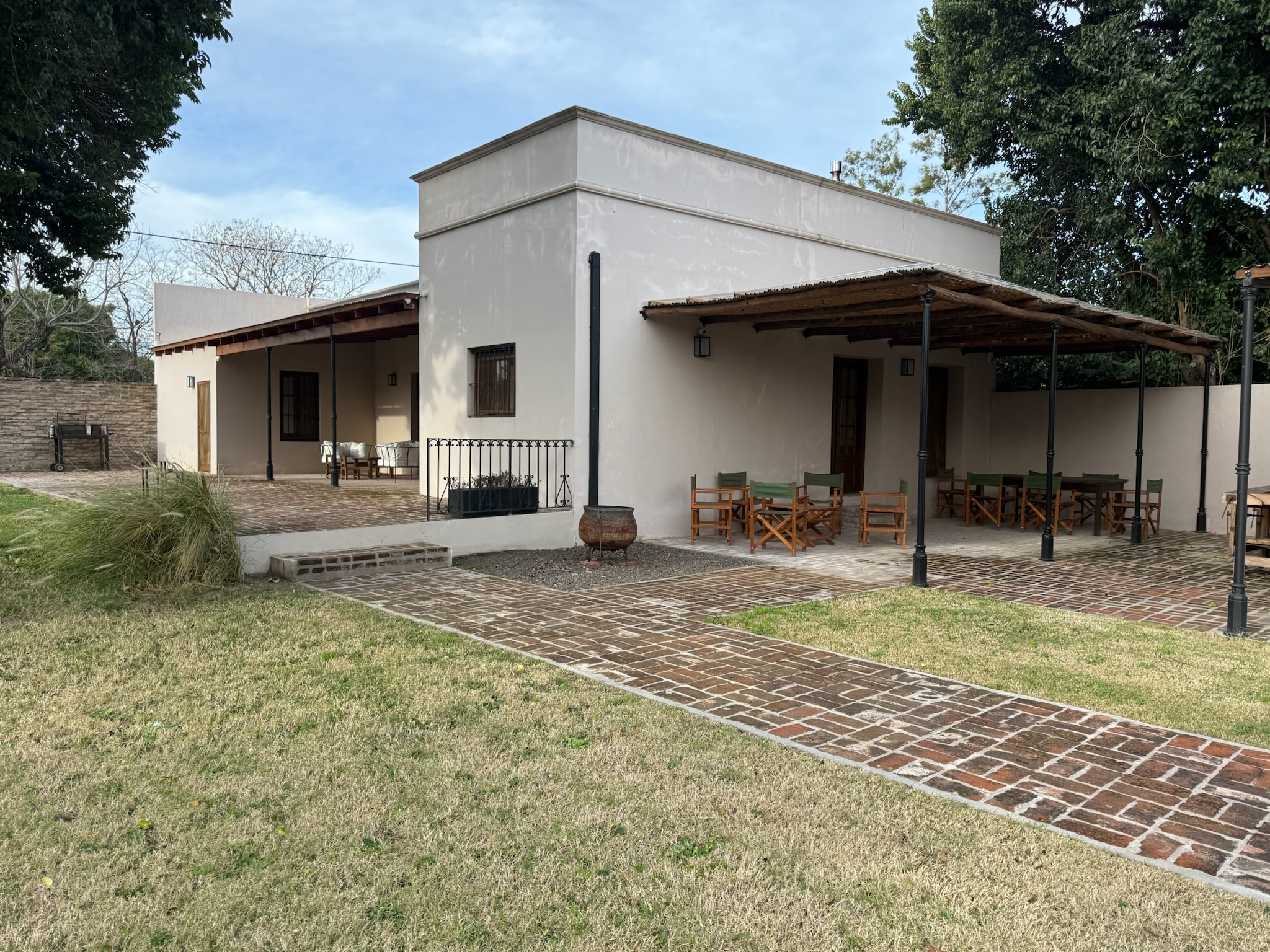 Exclusive lodge exterior at Las Tapias with outdoor seating, brick pathways, and lush greenery, showcasing a serene setting for bird hunting retreats.