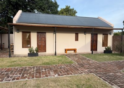 Newly constructed accommodations at Las Tapias dove hunting retreat, featuring a modern exterior, landscaped pathway, and inviting common areas, emphasizing privacy and luxury in Entre Ríos, Argentina.