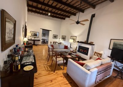 Luxurious interior of Las Tapias dove hunting lodge featuring elegant seating, wooden floors, and a cozy fireplace, highlighting refined accommodations and common spaces for an exclusive hunting experience.