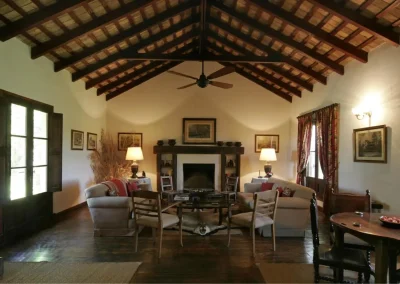 Cozy lodge interior at Las Vertientes in Argentina, featuring a high wooden ceiling, comfortable seating, and a warm fireplace, ideal for relaxation after wingshooting adventures.