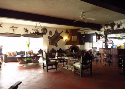 Interior of La Marina del Río lodge featuring rustic decor, comfortable seating, and a bar area, highlighting the welcoming atmosphere for hunters and guests.