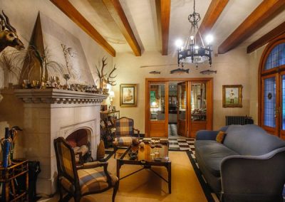 Elegant lodge interior at Estancia Santa Rita, featuring a cozy seating area, decorative fireplace, and rustic wooden beams, reflecting luxury and hospitality in Argentina's duck hunting destination.