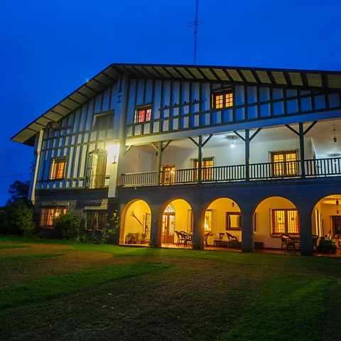 Basque-style lodge at Estancia Santa Rita, featuring warm lighting, arched entrances, and a lush green lawn, serving as a premier destination for waterfowl and perdiz hunting in Argentina.