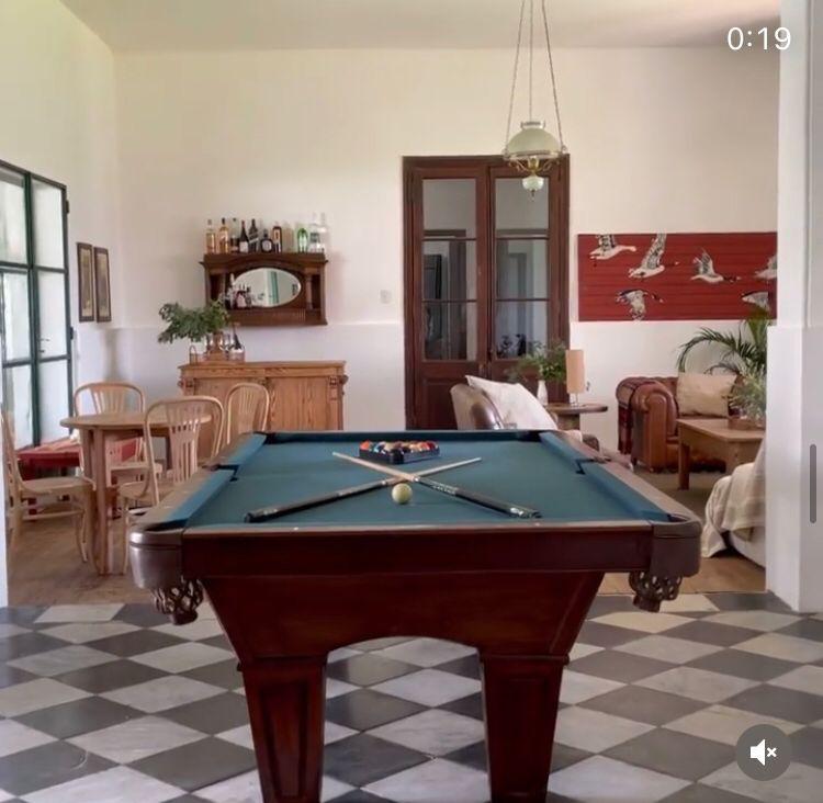Elegant lodge interior with a billiard table, wooden furniture, and decorative elements, showcasing a welcoming atmosphere for hunters in Uruguay.