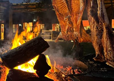 Traditional Argentine asado cooking over an open fire at Don Joaquín River Lodge.