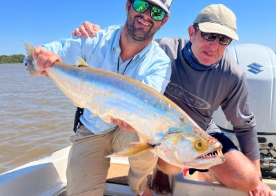 Anglers displaying a large Golden Dorado fish caught in Argentina's Corriente River.