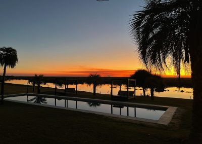 Don Joaquín River Lodge riverside setting at sunset and tranquil water reflections